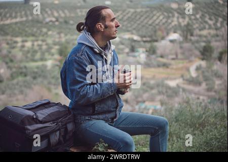 Junger attraktiver Mann mit Reiserucksack Wandern im Wald, frei genießen Natur und frische Umgebung auf früherer Frühlingswanderung, Looki Stockfoto