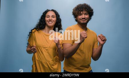 Multirassisches, vielfältiges Paar indischer Arabianer Mann Guy Hispanic Kaukasierin Mädchen tanzt zusammen zu Musik und genießt lustige aktive Bewegungen Stockfoto