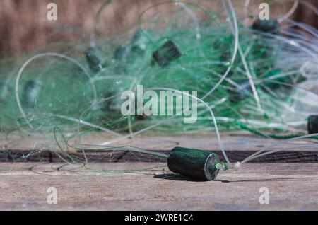 Das Fischernetz liegt auf einem hölzernen Pier am Flussufer. Stockfoto