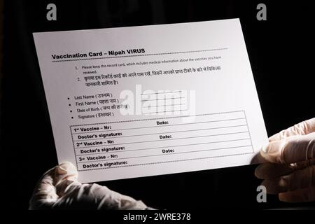 Ein Bild mit dunklem Hintergrund, das einen Arzt mit einer Impfkarte gegen das neue Nipah-Virus zeigt. Stockfoto