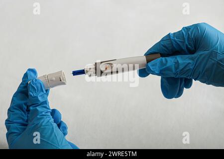 Medizin, Diabetes, Blutzucker, Gesundheit und Menschen Konzept - Vordergrund ein Arzt, der sich darauf vorbereitet, die Lanzette auf seinem Finger zu verwenden, um hohes Blut zu überprüfen Stockfoto