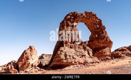 Tadrart-Landschaft in der Sahara, Algerien. Ein zarter roter Sandsteinbogen wurde von Wind und Sand des Tadrart geformt Stockfoto