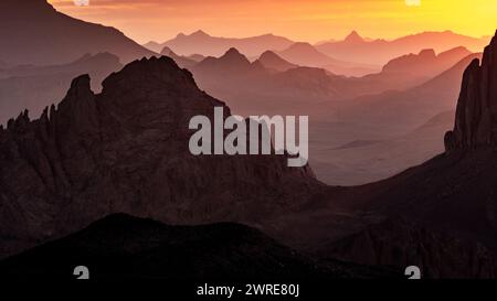 Hoggar-Landschaft in der Sahara, Algerien. Ein Blick von Assekrem auf den Sonnenaufgang über die Atakor Berge Stockfoto