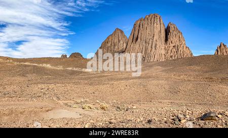 Hoggar-Landschaft in der Sahara, Algerien. Ein Blick auf die Berge und Basaltorgeln, die um die unbefestigte Straße nach Assekrem stehen. Stockfoto