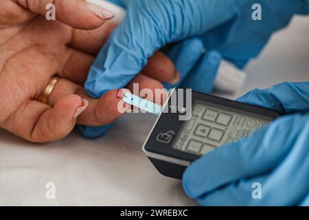 Arzt Kontrolle der Blutzuckerspiegel mit glucometer. Behandlung von Diabetes Konzept. Stockfoto