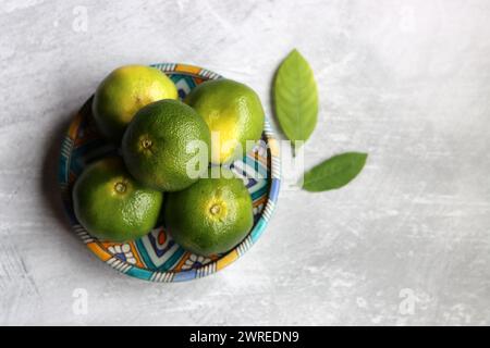 Grüne Mandarinen auf einer Keramikplatte. Nahaufnahme von frischen Zitrusfrüchten. Fresh-Konzept. Stockfoto