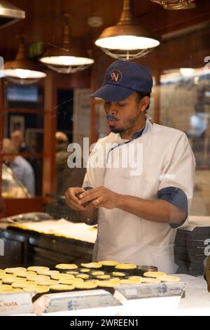 Der Küchenchef bereitet köstliche Gerichte in der belebten Restaurantküche zu und zeigt kulinarische Meisterleistungen in Aktion Stockfoto