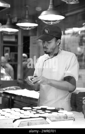 Der erfahrene Koch konzentriert sich auf die Zubereitung köstlicher Gerichte in einer Restaurantküche und zeigt kulinarische Expertise Stockfoto