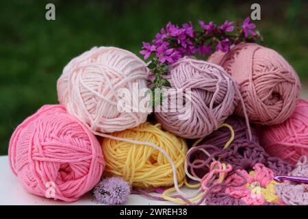 Rosafarbene und violette Garnklötze Nahaufnahme Foto. Wunderschöne weiche Bio-Baumwolle auf einem Tisch. Stockfoto