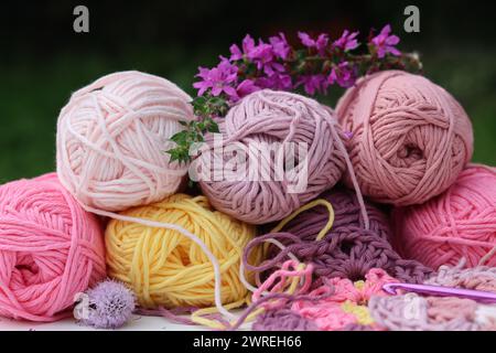 Rosafarbene und violette Garnklötze Nahaufnahme Foto. Wunderschöne weiche Bio-Baumwolle auf einem Tisch. Stockfoto