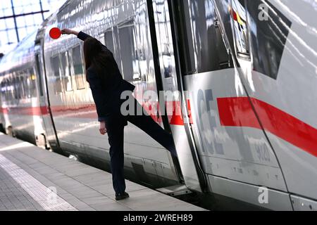 Streik der GDL am 12.03.2024 Hauptbahnhof in München. Ein ICE Zug steht zur Abfahrt bereit. Weiblicher Zugbegleiter signalisiert dem Lokführer mit roter Kelle, dass der Zug zur Abfahrt bereit ist. *** GDL-Streik am 12 03 2024 am Münchner Hauptbahnhof ist ein ICE-Zug bereit zur Abfahrt weibliche Zugbegleiterin signalisiert dem Triebfahrzeugführer mit einer roten Kelle, dass der Zug bereit ist zu fahren Stockfoto