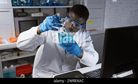 afroamerikanischer Wissenschaftler, der blaue Flüssigkeit in einem Kolben in einem modernen Labor analysiert Stockfoto