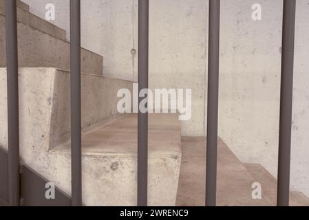 Teil der Treppe als Seitenansicht, mit den Metallstangen des Handlaufs vorne. Stockfoto