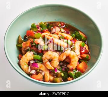 Ein lebendiger Garnelensalat mit frischem Gemüse in einer grünen Schüssel, der die gesunde Küche perfekt einfängt. Stockfoto