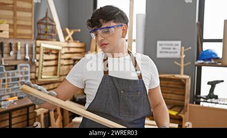 Der junge Mann untersucht Holzdielen in einer gut ausgestatteten Tischlerei. Stockfoto