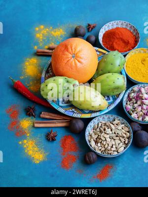 Stillleben mit bunten Früchten und Gewürzen auf einem Tisch. Foto von oben: Grapefruit, Paprika, Kurkuma-Pulver, Chili-Pfeffer, Ingwer, Rosen, Lavendel Stockfoto