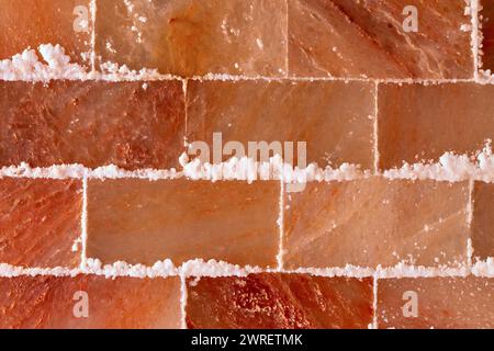 Texturierte Wand aus rosa Himalaya-Salz im Spa- oder Saunabereich Stockfoto