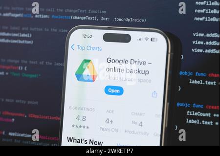 New York, USA - 23. Februar 2024: Google fährt auf dem iphone-Bildschirm mit unscharfem Code-Programmierhintergrund Stockfoto