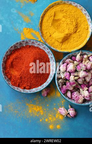 Getrocknete Rosenknospen aus nächster Nähe. Rosenblüten in einer blauen Keramikschale. Kräutertee-Zutat. Blauer Hintergrund mit Kopierraum. Stockfoto