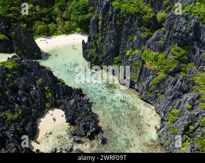 Klares Wasser mit Korallen und weißem Sand. Versteckter Strand. Matinloc Island. El Nido, Philippinen. Stockfoto