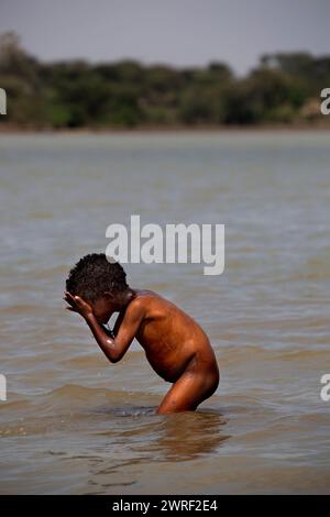 SOUTH OMO - ÄTHIOPIEN - 28. NOVEMBER 2011: Porträt des unbekannten afrikanischen Jungen, der im Fluss wäscht, am 28. November 2011 im Omo Rift Valley, Stockfoto