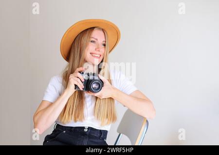 Junge Frau Model mit Retro-Filmkamera mit elegantem Hut Stockfoto