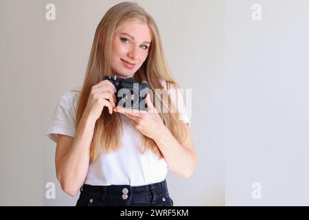 Junge Frau Model mit Retro-Filmkamera Stockfoto