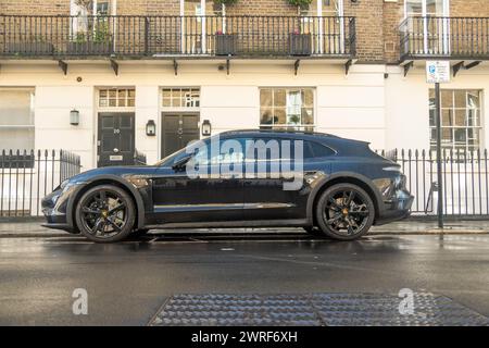 LONDON – 19. FEBRUAR 2024: Porsche Taycan 4S parkt in der eleganten Londoner Wohnstraße Stockfoto