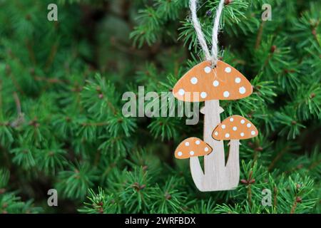 Holzspielzeugpilze auf den Zweigen eines Weihnachtsbaums. Handgemachte umweltfreundliche Urlaubsdekoration. Stockfoto