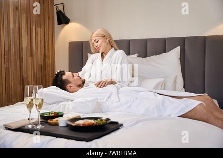 Ein verliebtes junges Paar ruht auf einem großen Bett Stockfoto