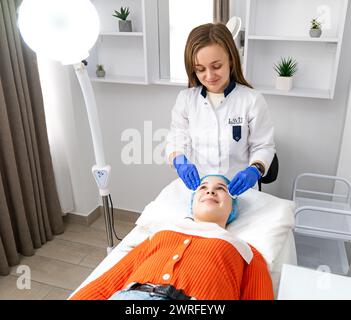 Ein Kosmetiker reinigt die Haut des Kunden eines Schönheitssalons vor dem Eingriff und der Gesichtsmassage. Das Konzept von Schönheit und Gesundheit. Kosmetologie Stockfoto