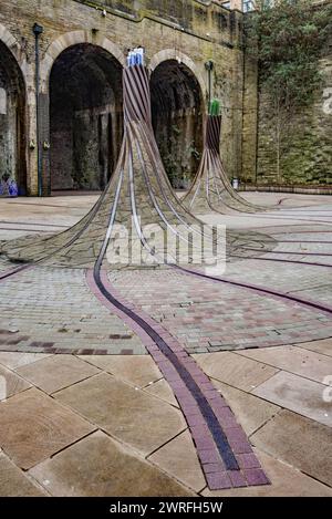 „Fibres“, eine standortspezifische Skulptur am St. Blaise Square, in der Nähe des Bahnhofs Forster Square, alte Eisenbahnlinien, kurvenförmige Säulen und Optik. Stockfoto