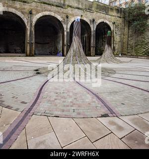 „Fibres“, eine standortspezifische Skulptur am St. Blaise Square, in der Nähe des Bahnhofs Forster Square, alte Eisenbahnlinien, kurvenförmige Säulen und Optik. Stockfoto