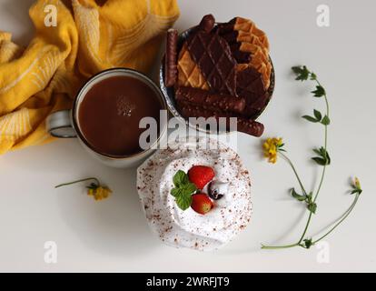 Eine Tasse Tee mit Milch, Waffeln und Keksen, Schlagsahne auf einem Tisch. Foto von oben. Englisches Teekonzept. Stockfoto