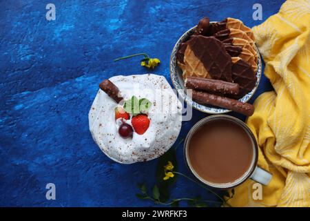 Eine Tasse Tee mit Milch, Waffeln und Keksen, Schlagsahne auf einem Tisch. Foto von oben. Englisches Teekonzept. Stockfoto