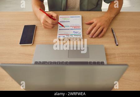 Mann Planungstag in Notizbuch mit Bleistift Stockfoto
