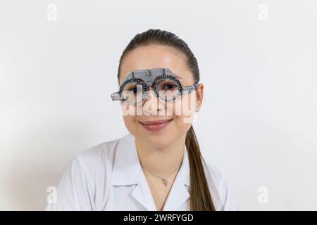 Porträt einer lächelnden Frau, die eine Brille trägt, die in der Augenheilkunde zur Kontrolle des Sehvermögens verwendet wird. Augenbrille. Hoher ph-Wert Stockfoto