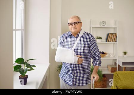 Porträt eines Seniorenmannes in der Rehabilitation mit Krücke und Arm in Gipsverband. Stockfoto