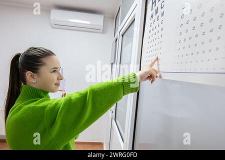 Ein sehr attraktiver Patient und glücklich, dass er sehr gut Sehvermögen hat, ist in der Praxis eines Sehspezialisten und Augenspezialisten. Stockfoto