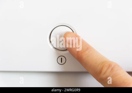 Zugeschnittene Ansicht der Hand einer Frau, die einen Knopf auf einem Haushaltsgerät drückt Stockfoto