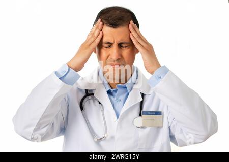 Studio-Aufnahme eines gutaussehenden jungen männlichen Arztes, der unter Kopfschmerzen vor weißem Hintergrund leidet Stockfoto