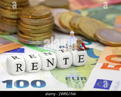 miniatur-alter Mann, der auf Buchstabenwürfeln sitzt, RENTE, das deutsche Wort für Rente, mit Euro-Geldbankoten und -Münzen Stockfoto