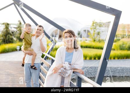 Zwei Leute, ein Mann und eine Frau, die in der Mitte einer Brücke stehen und auf die Aussicht blicken. Die Brücke besteht aus Stahl und überblickt einen Fluss darunter. Stockfoto