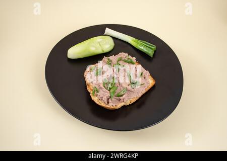 Leberpastete, auf einer Scheibe geröstetes Brot mit Frühlingszwiebeln bestreut Stockfoto