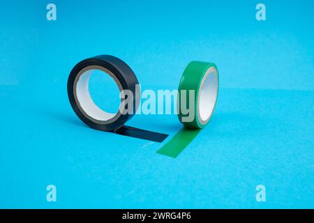 Grünes und schwarzes Klebeband auf blauem Hintergrund, weicher Fokus Stockfoto
