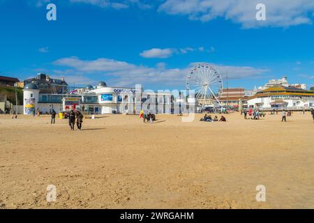 Bournemouth, Großbritannien - 2. April 2023: Menschen am Strand vor dem Ozeanarium und dem Aussichtskrad. Stockfoto