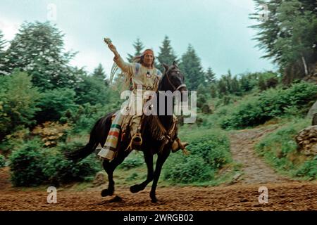 Der Schauspieler Pierre Brice tritt als Winnetou auf, der über die Bühne reitet in dem Stück der Schatz im Silbersee von Karl May, Pferd, Freilichttheater Elspe, Sauerland, Nordrhein-Westfalen, Deutschland, Juni 1982 Stockfoto