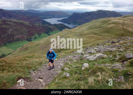 Lone man (Wanderer) geht auf dem Ridge Path zum Wainwright „St Sunday Crag“ über dem Ullswater Lake in Patterdale, Lake District National Park, Cumbria. Stockfoto