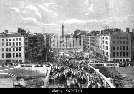 Grundstein für das O'Connell Monument in der Sackville Street, Dublin, 1864. Kupferstich aus einem Foto von Mr. W. H. Monney. "...die Straßen Dublins waren voller Menschen, die grüne Schärpen und Rosetten trugen, und jeder Punkt, von dem aus man einen Blick auf die Prozession hatte, war mit Zuschauern überfüllt... bei der Prozession, die um Mittag begann... übernahmen die damit verbundenen Berufe die Führung. Gegen ein Uhr wurde das Rathaus durch das erste grüne Banner mit der Aufschrift "Erinnerung an O'Connell, den Unsterblichen Befreier"... verschiedene römisch-katholische Gesellschaften... nächste Appelle Stockfoto