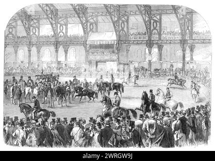 The Horse Show in the Agricultural Hall, Islington, [London], 1864. "...ein allgemeiner Blick auf das Innere der Halle, während der Pferdeparade, die zu bestimmten Zeiten jeden Tag stattfand, während die Ausstellung geöffnet war... am Montag, dem ersten Shilling-Tag... wurde die königliche Box von der Herzogin von Wellington besetzt, der Herzogin von Beaufort, und eine Gruppe der Aristokratie... während der fünf Tage wurde eine große Anzahl von Verkäufen von wertvollen Pferden getätigt, die ausgezeichnete Preise erzielten, und unter den Käufern waren viele Ausländer... die Gesamtzahl der Tiere in der Show betrug 310, und sie beinhalteten Stockfoto